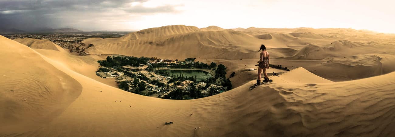 Girl on sandboard admiring the Huacachina Oasis